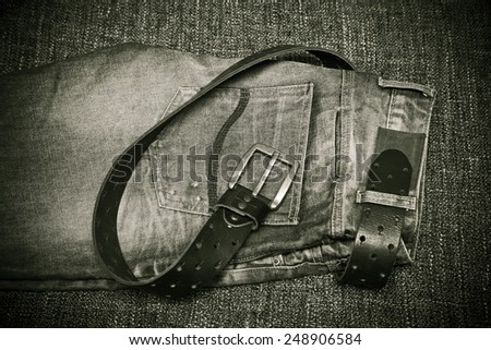 Fashion trend - jeans, a leather belt with a buckle. Black and white photo in vintage style