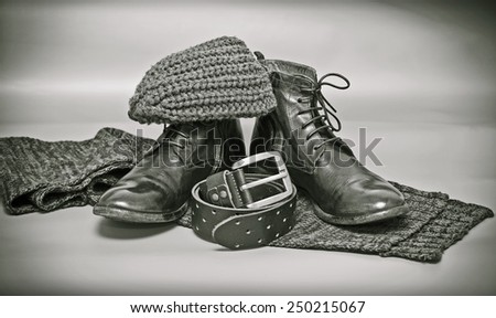 still life of garments: knitted scarf and hat, leather shoes, leather belt with a buckle. retro Style