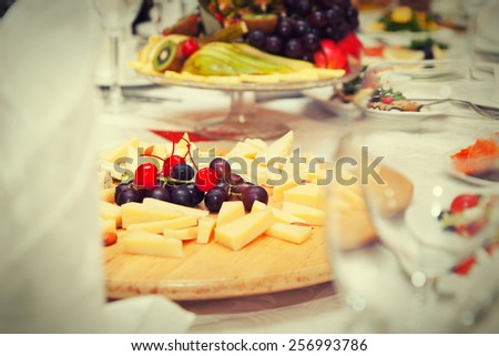 Covered table in the restaurant - cheese plate, fruit plate