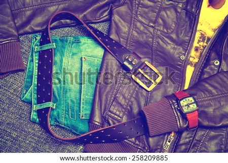 Clothing items and accessories: blue jeans with a leather belt, leather jacket, T-shirt, watches