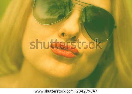 The girl in sunglasses kissing lips