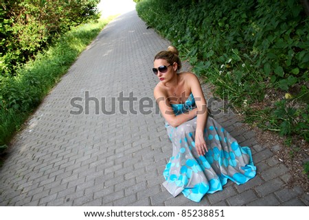 Girl in a turquoise dress sitting on his haunches