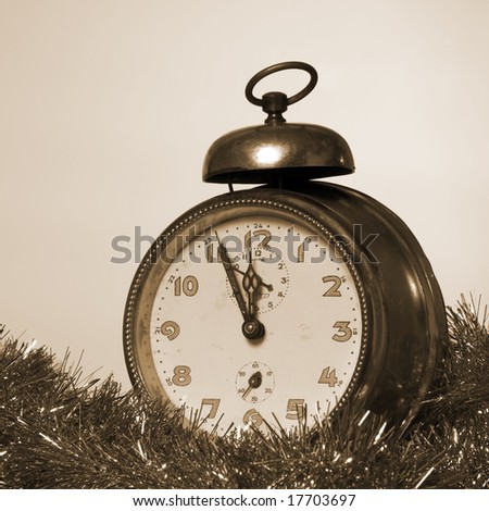 Old Alarm Clock showing few minutes to twelve sepia tone