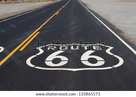A route 66 highway shield painted on a new road in the California desert