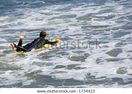Surfer going into the surf with long board