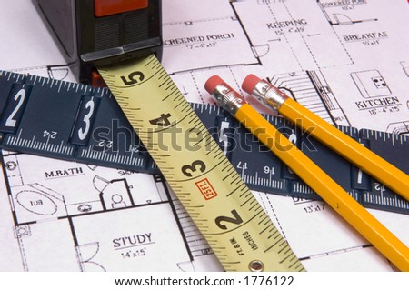 Measuring tape and ruler on red background and house floorplan