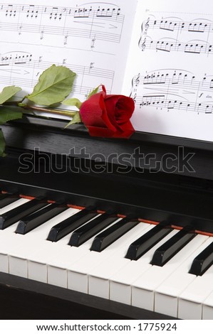 Sheet music with rose  on piano