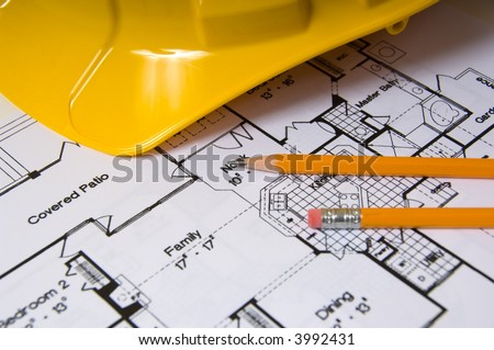 House floor plan with pencils and a yellow hard hat