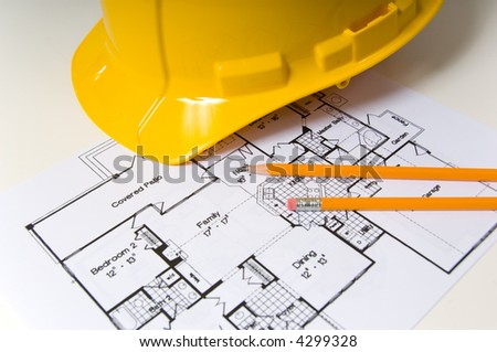 House floor plan design with pencils and a yellow hard hat