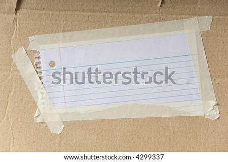 Blank note taped to cardboard box - insert your own text or graphics