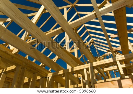 Housing construction industry with the frame of a house with wood against a blue sky