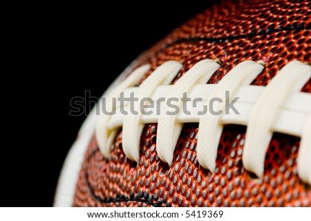 Brown leather american football on black background