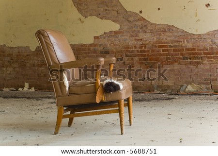 An old abandoned chair left in an abandoned dilapidated building.  Interesting how the colors of the building and the chair match- space for copy