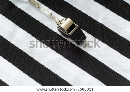 black and white striped referee jersey with a whistle to the left, copy space on the right hand side of image