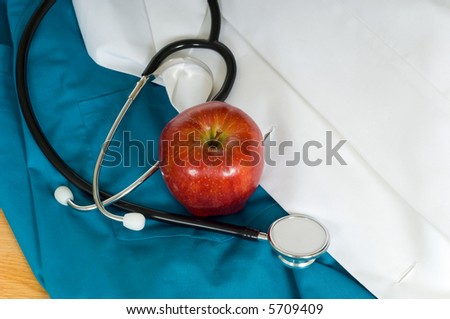 Doctor, physician or nurse items including medical scrubs, a labcoat, a stethoscope and an apple