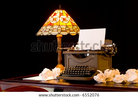 Old, vintage, antique, typewriter in writer\'s or author\'s work space with desk lamp, illustration of writer\'s block