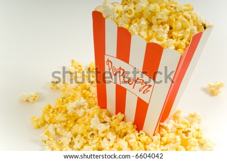 Movie popcorn on white background with red striped box and freshly popped popcorn on white background