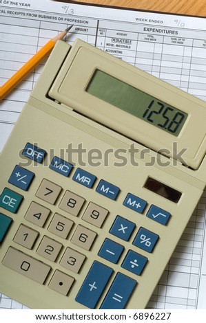 Items used in small business accounting including a calculator and an accounting ledger