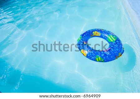 a wide angle view of a child\'s inflatable swim  ring or toy in a swimming pool with copy space