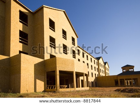A commercial construction zone for apartments or a hotel against a blue sky background