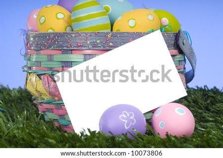 A blank notecard or card with a overflowing basket of Easter eggs add message or graphics to copy space