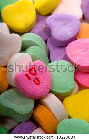 A stack of candy conversation hearts with one turned up with the words \