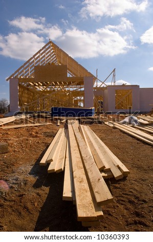 New home under construction with wood, trusses and supplies