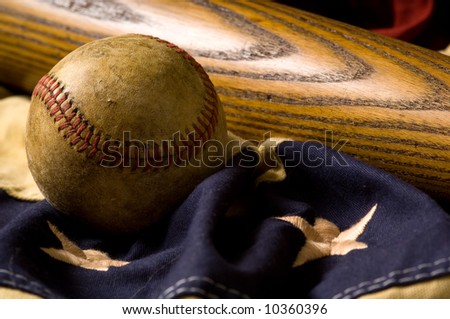 A vintage or antique baseball and baseball bat on American flag bunting