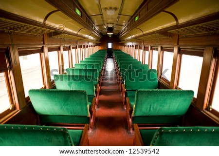 Wide angle view of the inside of a vintage, antique passenger train cabin