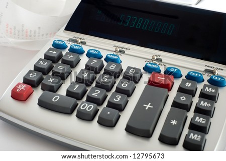 An adding machine or calculator with adding machine tape or paper.