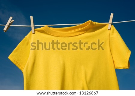 Individual t-shirts on a clothesline in front of a beautiful blue sky.  Add text or graphics to shirts, copy space