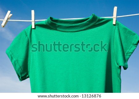 Individual t-shirts on a clothesline in front of a beautiful blue sky.  Add text or graphics to shirts, copy space
