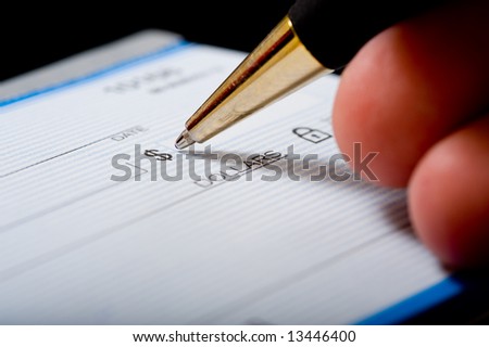 A macro of a ball point pen begining to write a signature on a check