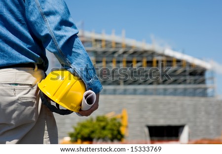 A construction worker or foreman at a construction site observing the progress of construction job or project, with copy space