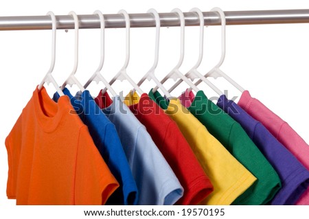 A row of colorful row t-shirts hanging on hangers on a white background