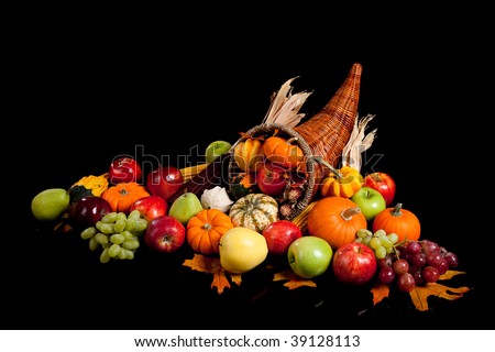fall arrangement of fruits and vegetables in a cornucopia on a black background