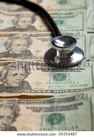 A stethoscope on a background of $20 bills- healthcare cost concept