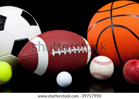 Assorted sports balls including a basketball, american football, soccer ball, tennis ball, baseball, golf ball and cricket ball on a black background