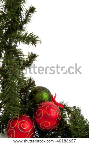 Green Christmas garland with red and green ornaments/baubles on a white background with copy space