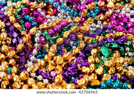Background made up of mulit-colored including gold, purple, blue, green and pink mardi gras beads