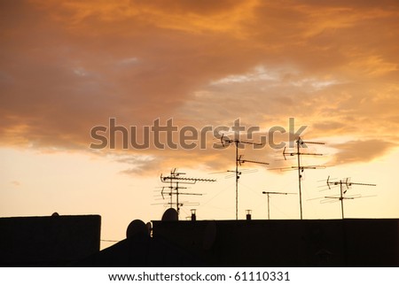 silhouettes of antennas on the roof at sunset