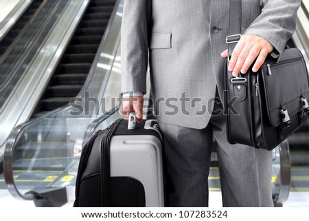 Travelling Businessman.  Businessman with his luggage near an escalator at an airport