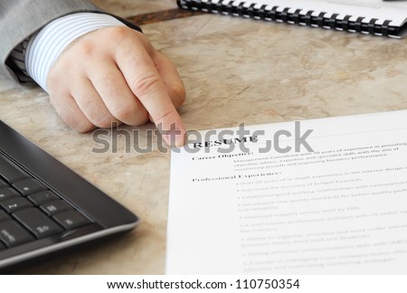 Job Interview in the Office with male hand and Resume on the Table