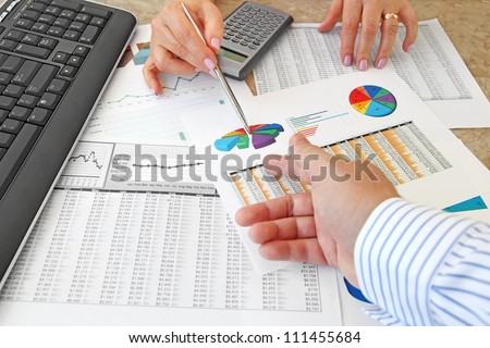 Analyzing Data  Closeup of Hands with Financial  Charts  at Business Meeting in the Office