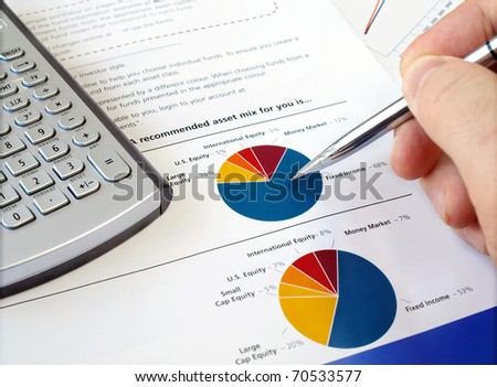 Male hand with pen on the investment chart with calculator