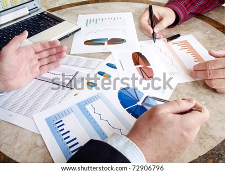 Closeup of hands with financial  charts  at business meeting in the office