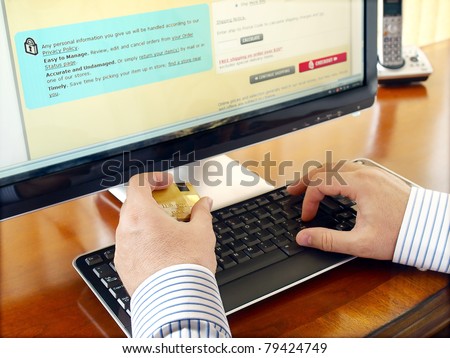 Businessman with credit card using computer for online purchase.