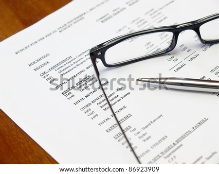 Glasses and pen on the budget document