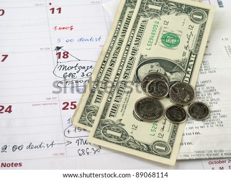 Receipts with dollar bills and coins on the monthly planner