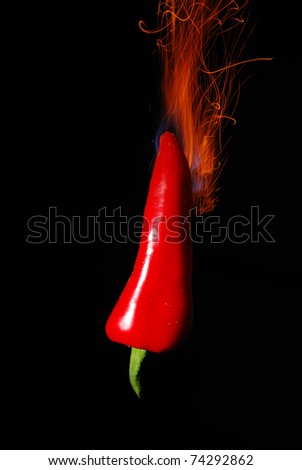 Chili pepper on fire with black background